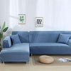 Sofá azul con chaise longue y cojines a juego en un salón moderno, ilustrado con una planta y cuadros decorativos en la pared, disponible en blueemoonco.com, especialistas en fundas de sofá y silla.