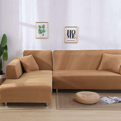 Funda de sofá elástica color camel en sala de estar minimalista con decoración de plantas y cuadros
