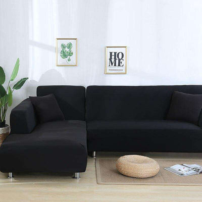 Fundas de sofá negras en salón moderno con decoración minimalista y plantas verdes, perfectas para la renovación de interiores, disponibles en blueemoonco.com