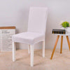 Funda de silla blanca universal en una silla de comedor moderna, con decoración de una mesa lateral y flores, ideal para ventas en tiendas online de cubiertas para muebles en blueemoonco.com