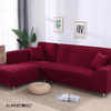Funda de sofá esquinero color rojo burdeos en una sala de estar luminosa con decoración minimalista, ideal para renovar y proteger el mobiliario.