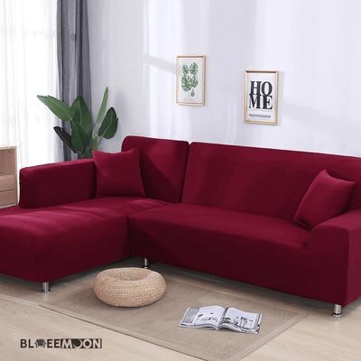 Funda de sofá esquinero color rojo burdeos en una sala de estar luminosa con decoración minimalista, ideal para renovar y proteger el mobiliario.