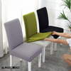 Fundas de silla ajustables en colores morado, verde y negro de Blueemoonco.com, mostradas en sillas blancas en un entorno luminoso, ideales para decoración moderna y protección del mobiliario.