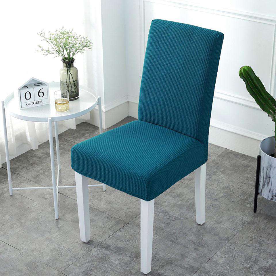 Fundas de silla color verde azulado en tejido de punto, ajustables y elásticas, perfectas para decoración de interiores. Disponibles en blueemoonco.com, especialistas en cubiertas para sillas y sofás en España y la UE.