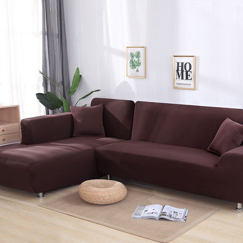 Funda de sofá elástica color marrón en sala de estar moderna con plantas decorativas y cuadros con mensajes de 'hogar', perfecta para la renovación de muebles.